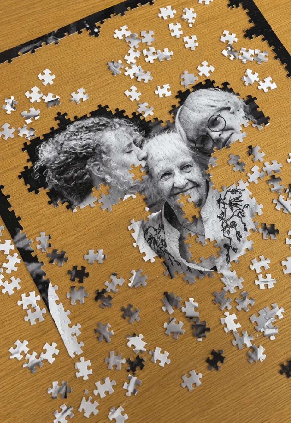 A half-finished puzzle made from a photograph of three family members.